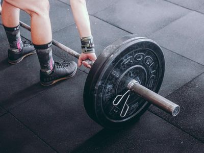 Man hands holding a heavy barbell bar in a gym